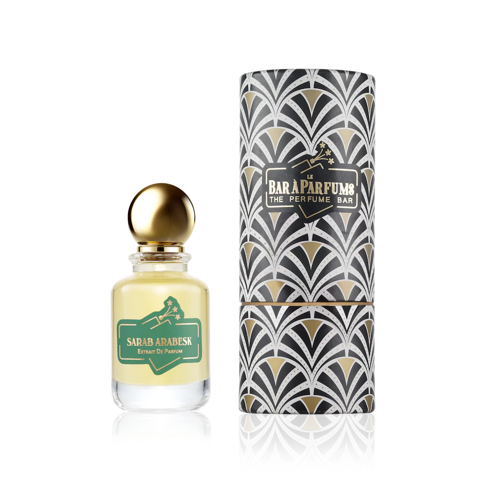Perfume bottle with gold cap and decorative packaging on a white background